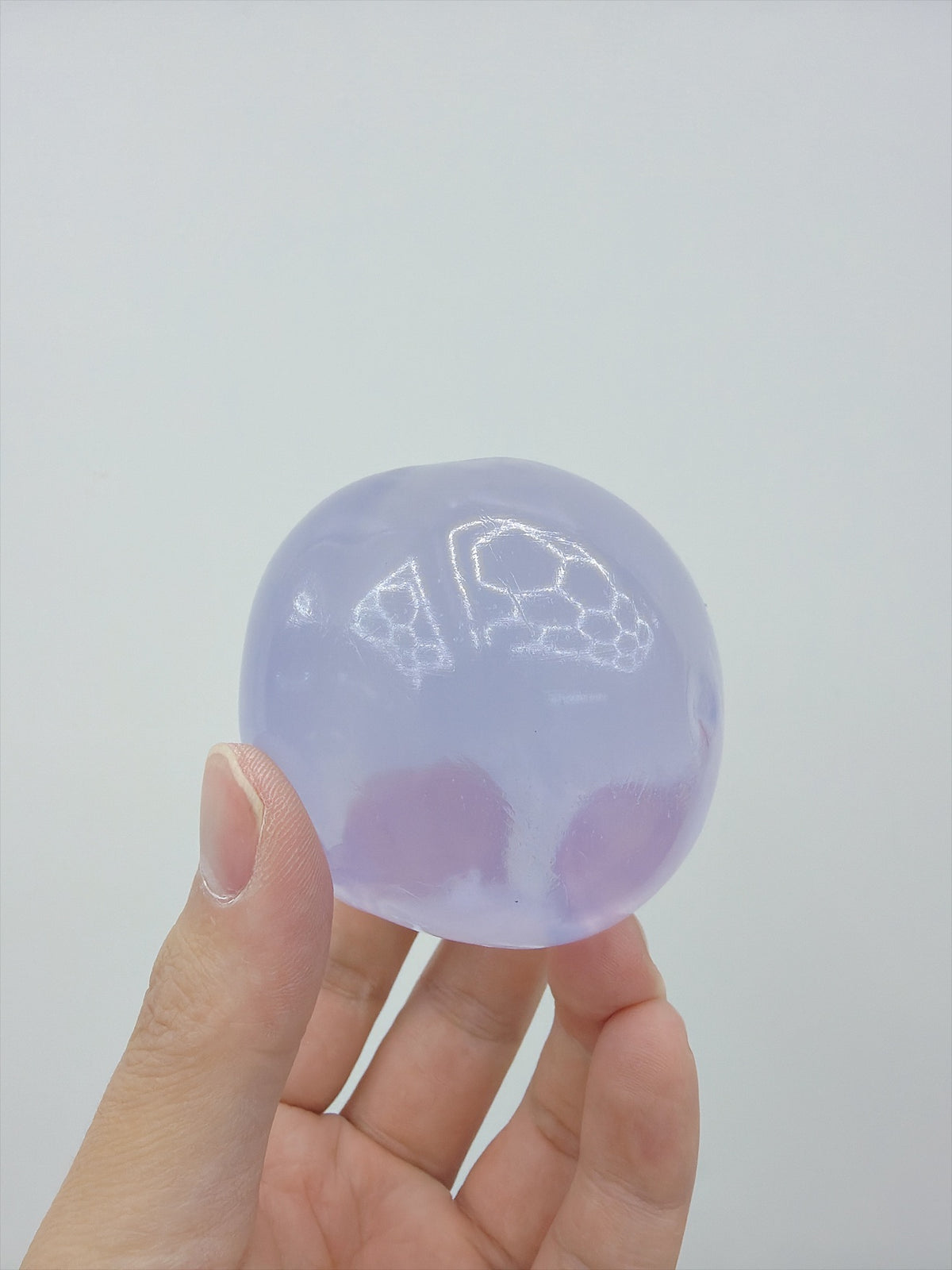 Real Touch Me clear Vaseline ball squishy in Purple in hand