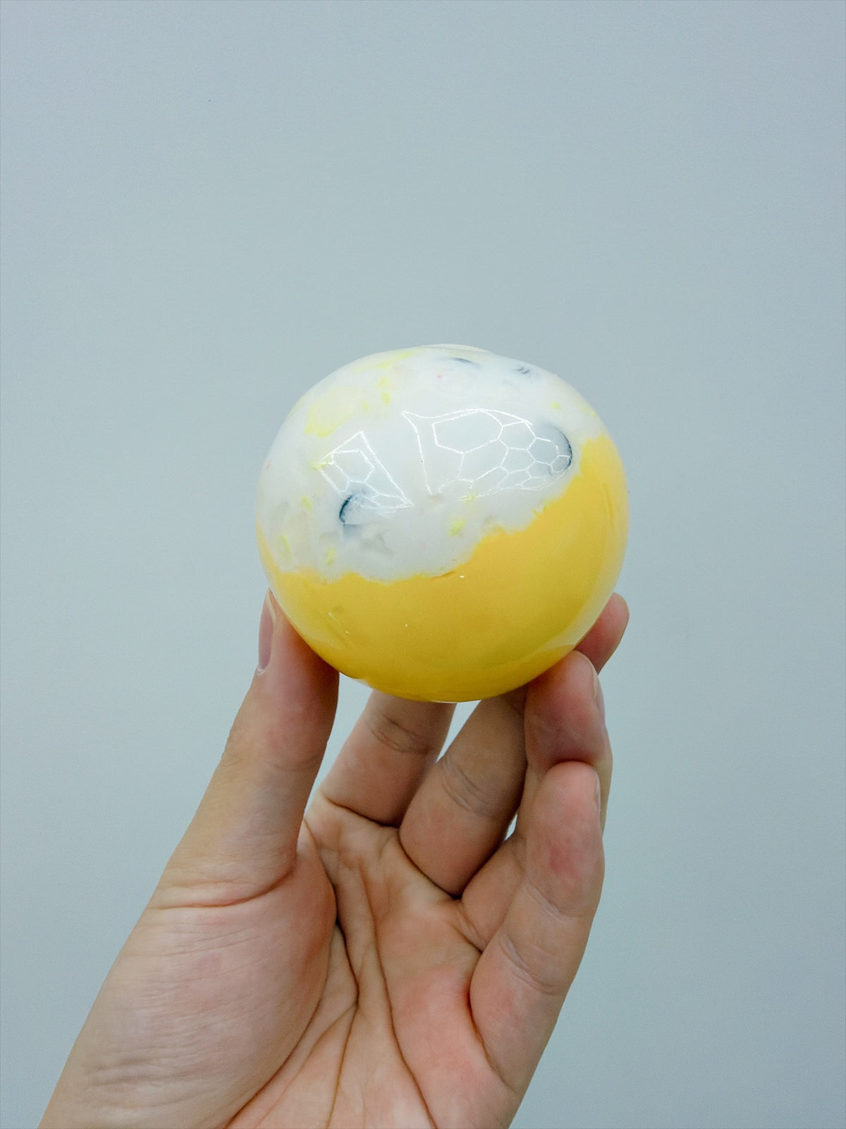 Real Touch Me two-tone crunchy ball squishy in Yellow in hand