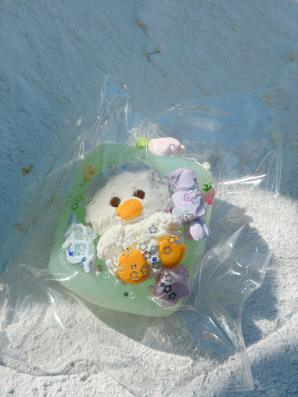 Wonder Village mint chick squishy with white chick, orange beak and feet, purple bow and star sequins, in a clear bag