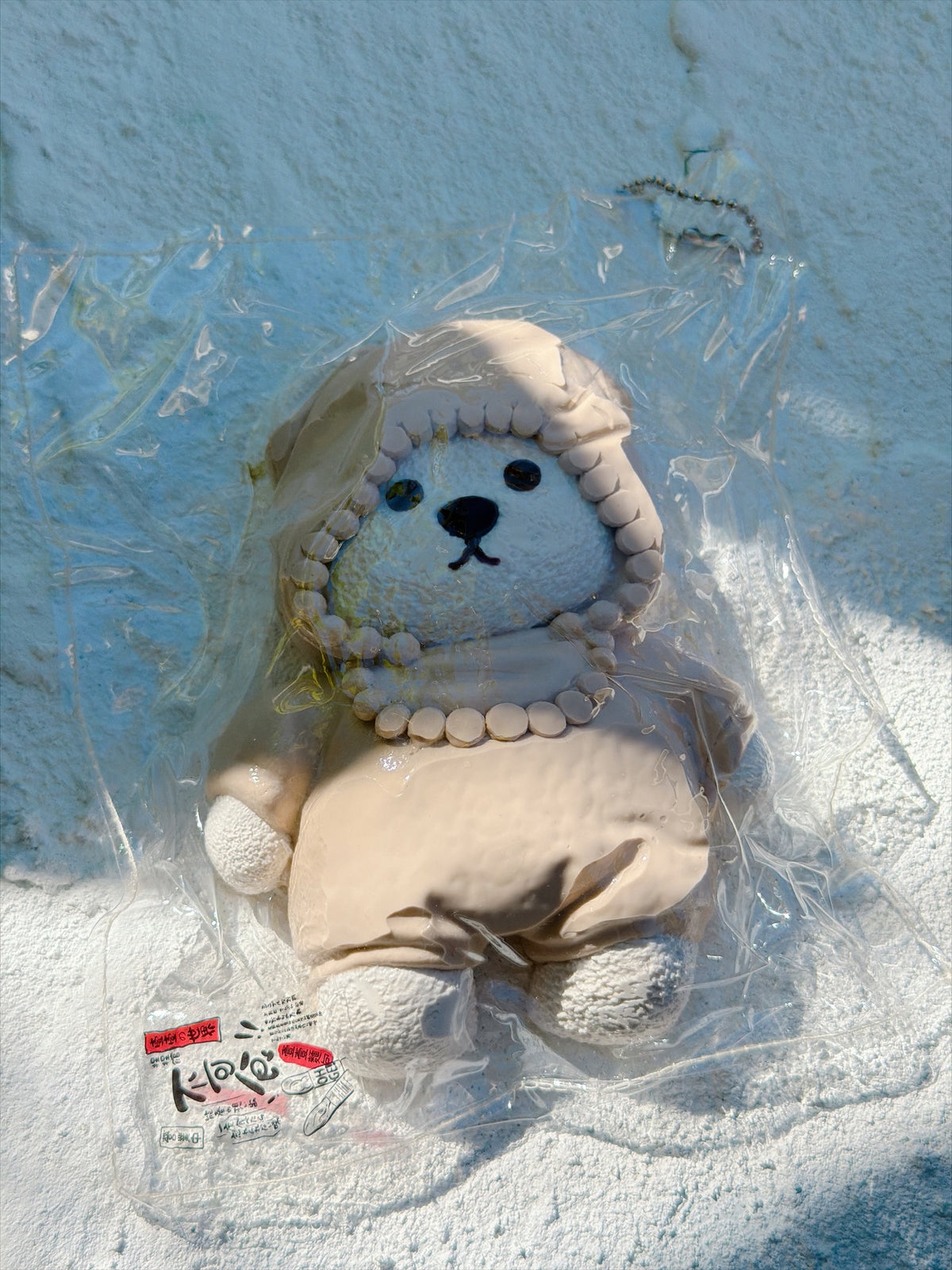Wonder Village hooded bear squishy in a beige hooded outfit, in a clear bag